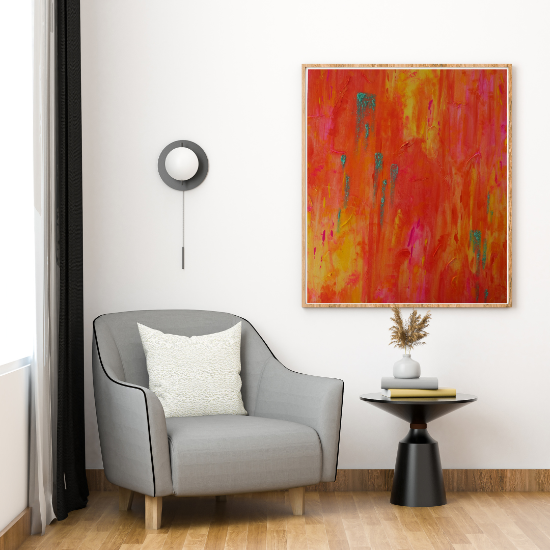 Eine moderne Wohnzimmerecke ist mit einem grauen Sessel, einem weißen Kissen, einem runden schwarzen Beistelltisch, getrockneten Blumen und „Feuerwerk“, einem Originalen Kunstwerk von maridy art – einem abstrakten Ausbruch von Rot und Orange – über einem hellen Holzboden ausgestattet.