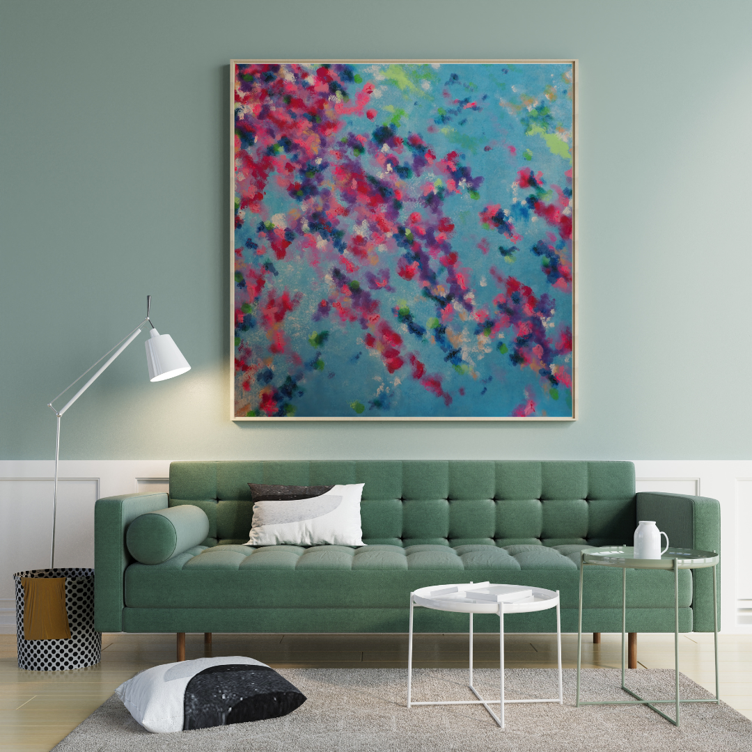 Ein modernes Wohnzimmer mit einem grünen Polstersofa strahlt Frische und Vitalität aus. Es ist mit weißen und schwarzen Kissen, runden weißen Tischen, einer Stehlampe und „Blütenmeer“ von maridy art – einem farbenfrohen abstrakten Gemälde – an einer blauen Wand ausgestattet.